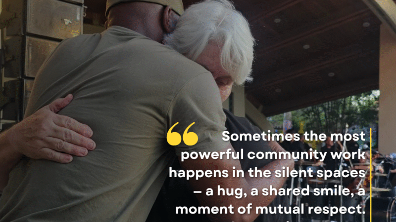 D’Andre Lampkin and Dr. Sylvia Mann embrace in a hug during community event