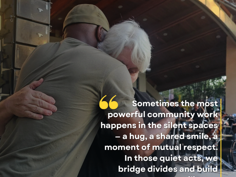 D’Andre Lampkin and Dr. Sylvia Mann embrace in a hug during community event