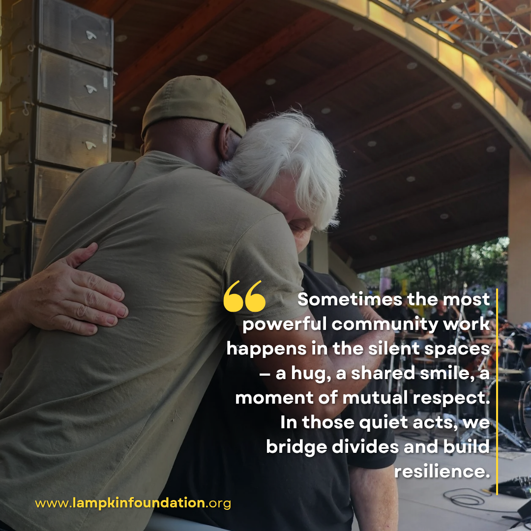 D’Andre Lampkin and Dr. Sylvia Mann embrace in a hug during community event