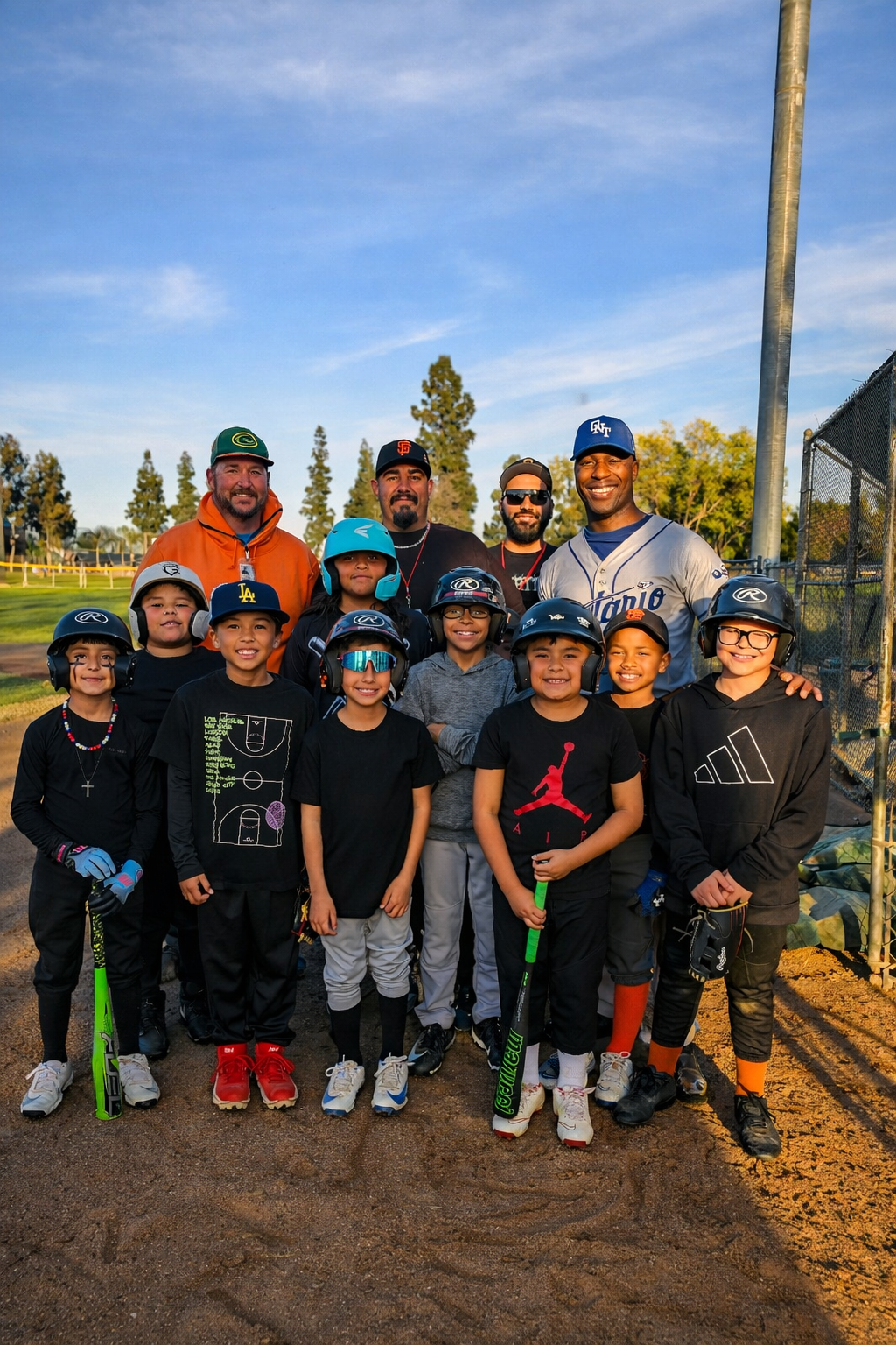 Ontario youth Little League players and coaches gathered on a baseball field during golden hour, representing Ontario Mountain View Little League AAA sponsored by the D’Andre D. Lampkin Foundation.