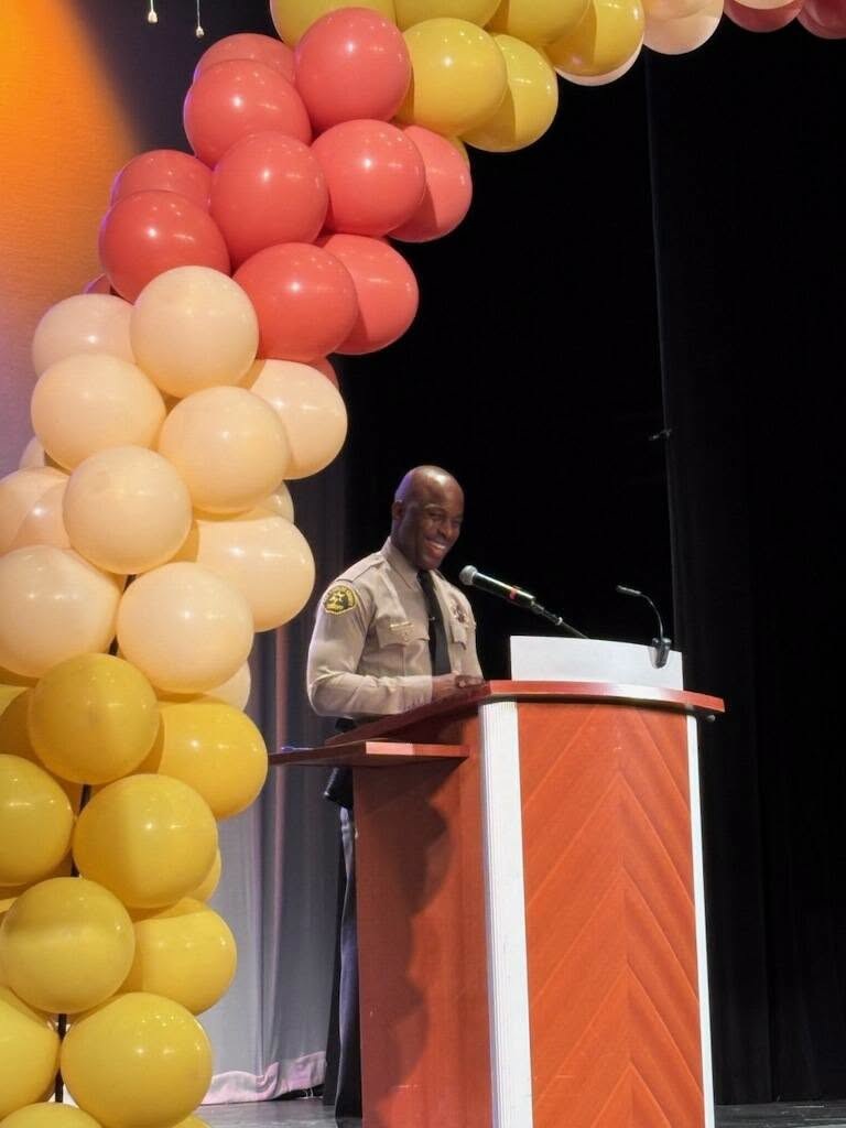 D’Andre Lampkin smiles while speaking from the podium during the Los Angeles County Parks and Recreation Teen Summit.